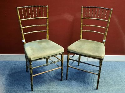 une paire de chaises Chiavari dorées avec des assises rembourrées vertes