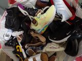 many pairs of shoes in a bag on the floor