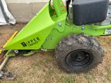 a small green machine that is sitting in the grass