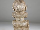 an image of a sculpture of a person sitting on top of a pile of rocks