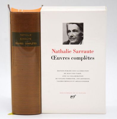 an old book with a picture of a man sitting next to it