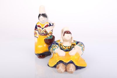 two figurines of a woman and a man sitting next to each other
