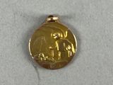 a gold medal with a picture of a man and a woman on it