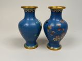 pair of blue vases with floral designs on them on a white surface