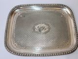 un plateau en argent ancien posé sur une table blanche, orné d'une image représentant un cheval