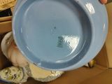 a person holding a blue bowl in a cardboard box