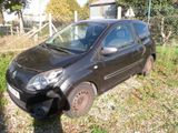 a small black car that is parked on the side of the road