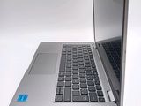a silver laptop with a black keyboard on a white surface