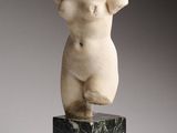 statue en marbre représentant un torse féminin, posée sur un socle en marbre