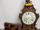 a clock that is sitting on a table next to a chest