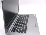 a silver laptop with a black keyboard on a white surface