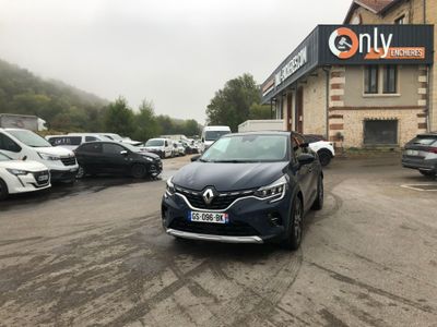 une voiture garée devant un immeuble devant lequel sont garées d'autres voitures