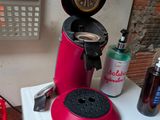 a red coffee maker sitting on top of a white counter