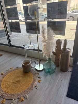 une table sur laquelle se trouvent un vase et un tapis, placée devant une fenêtre