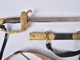 une épée avec une poignée en or sur une surface blanche