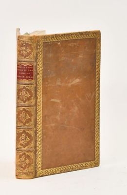 a brown book with gold trim sitting on a white surface