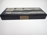 une boîte noire portant une étiquette, posée sur une table blanche