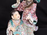 a figurine of a woman and a child sitting on a black background
