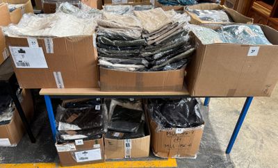 many boxes of items on a table in a warehouse