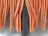 a close up of an orange bench with rope on it