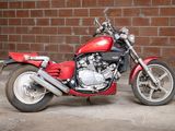 a red motorcycle that is parked in front of a brick wall
