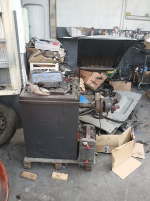 un tas de vieilleries dans un garage, avec un camion en arrière-plan