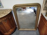 un miroir posé par terre à côté d'une armoire