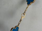 a close up of a gold chain bracelet with blue hearts on it