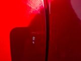 a close up of a red car door with a black handle