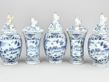 six blue and white vases are lined up against a gray background