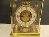 une horloge en or posée sur une table blanche