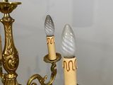 a gold chandelier with three candles on each of it