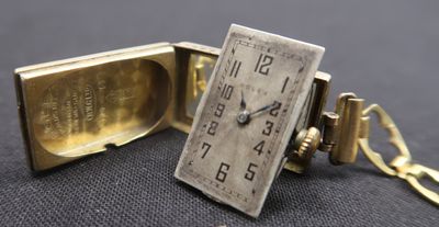 une montre en or à laquelle est attaché un porte-clés