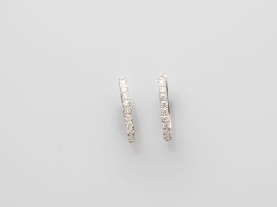 a pair of diamond hoop earrings on a white background