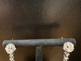 gros plan d'une paire de boucles d'oreilles sur un support