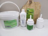 a bucket of liquid, a container of glue, and a container of glue on a table
