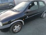 a small black car that is parked in a parking lot