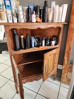 une armoire en bois sur laquelle sont posés de nombreux produits capillaires