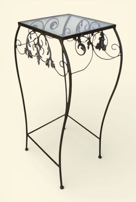 une table en fer avec un plateau en verre sur fond blanc
