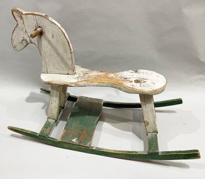 a wooden rocking horse that is sitting on a white surface