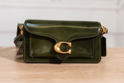 a green purse sitting on top of a wooden table