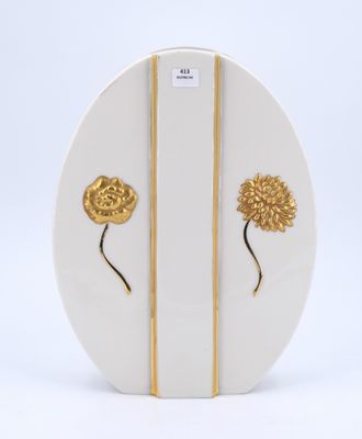 une assiette blanche ornée d'un motif floral doré