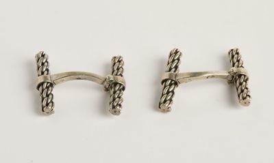 une paire de boutons de manchette en argent sur fond blanc