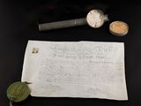 un vieux journal sur lequel est posé un bout de papier, à côté d'autres objets