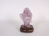 une petite figurine représentant un homme, ornée d'un cristal rose