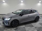 Une voiture grise est garée sur un sol à damier dans un showroom.
