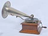 an old silver gramphone with a wooden base and a wooden stand