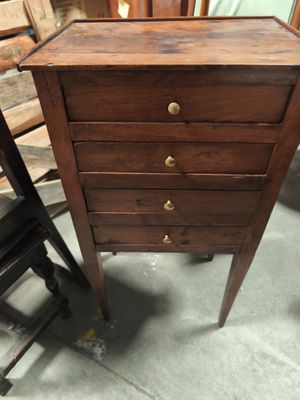 une petite commode en bois dans un coin de la pièce