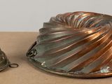 a metal cake pan and a metal mold on a table
