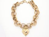 a gold bracelet with a heart charm on it